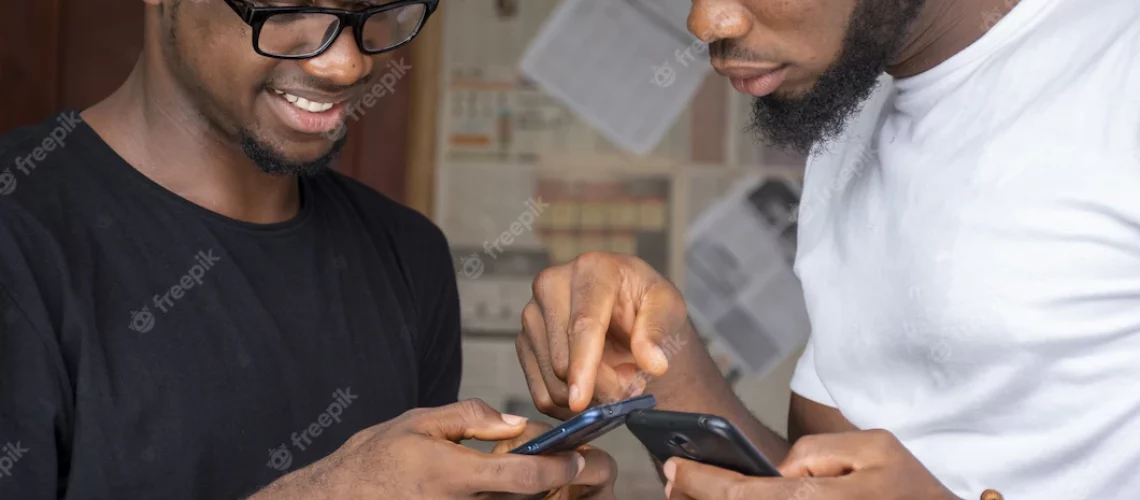 shallow-focus-two-young-african-males-sharing-content-through-their-phones_181624-44999
